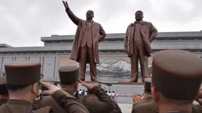 Soldados norcoreanos saludando a las estatuas de los dos primeros líderes del país